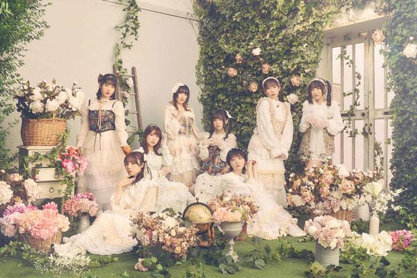 DIALOGUE+團體合照,穿著白色洋裝,周圍環繞著花卉和綠色植物。