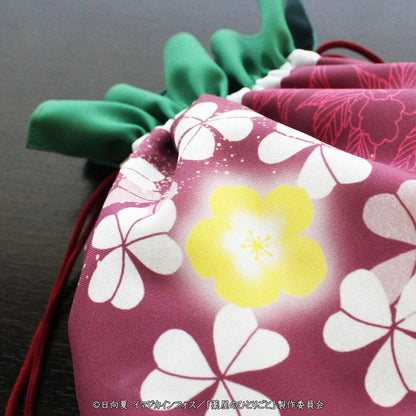 藥師少女的獨語貓貓抽繩袋特寫，紫色底白色和黃色花朵圖案，綠色束口。