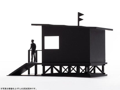 金曜Roadshow模型：黑色瞭望台建築，頂部有旗幟，旁邊站立一個人偶。